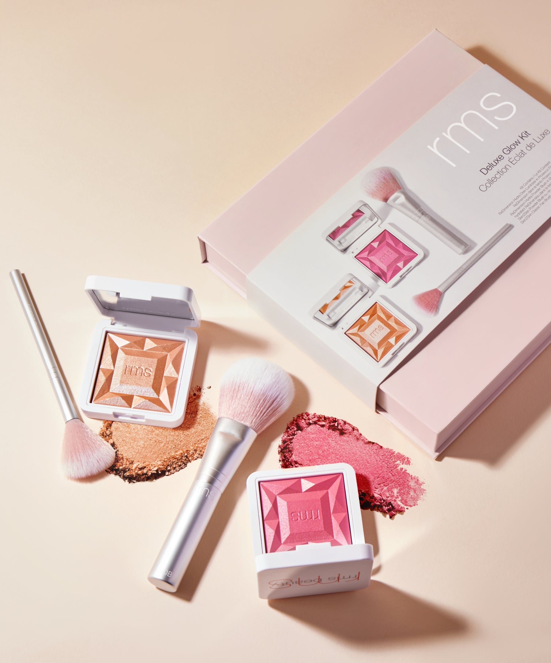 RMS Deluxe Glow Kit featuring RMS Skin2Skin Classic Fan Brush, Skin2Skin Powder Blush Brush, ReDimension Hydra Powder Blush in the exclusive shade Bermuda Rose, and ReDimension Hydra Dew Luminizer in shade Prosecco Fizz.